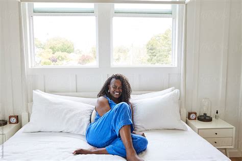 Portrait Of Mature Black Woman Relaxing In Bedroom At Home Del Colaborador De Stocksy
