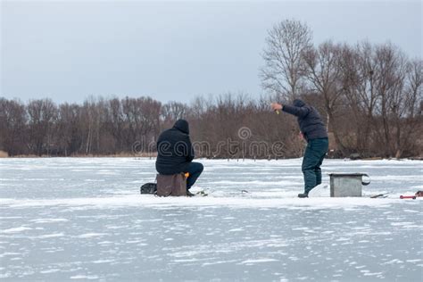 Pesca De Hielo En El Hielo Que Un Pescador Sienta En Un Cofre De Pesca