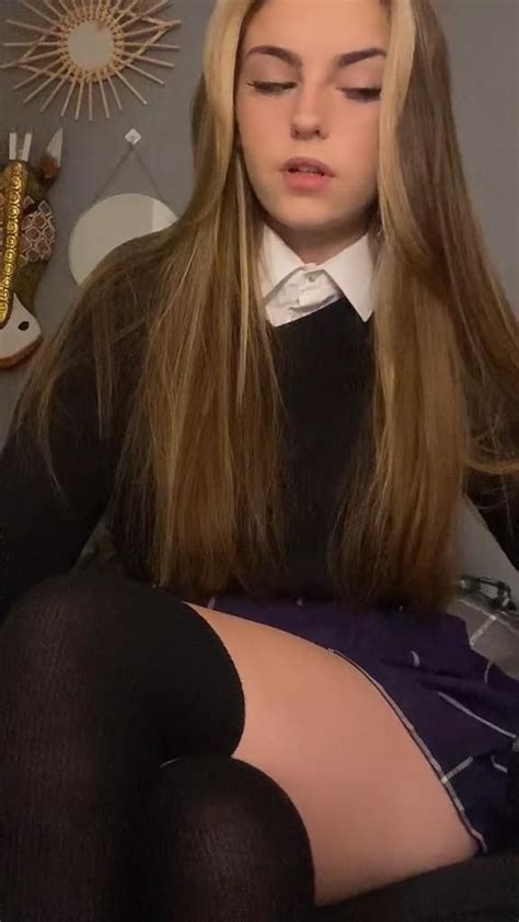 A Girl With Long Blonde Hair Sitting In A Chair Wearing Black Stockings And Knee High Socks