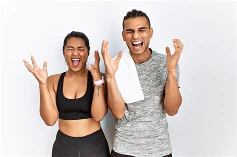 Joven Pareja Latina Con Ropa Deportiva De Pie Sobre Un Fondo Aislado Celebrando Loco Y Loco Por
