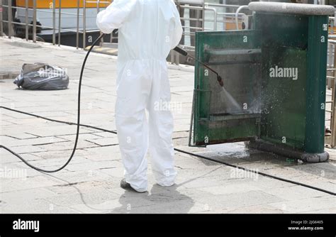 Sanitizer Worker During The Cleaning Of Street Furniture With A