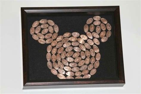 A Mickey Mouse Head Made Out Of Coins In A Wooden Frame On The Wall