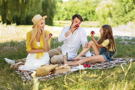 Familia Feliz Que Tiene Comida Campestre Y Que Come Manzanas En Parque