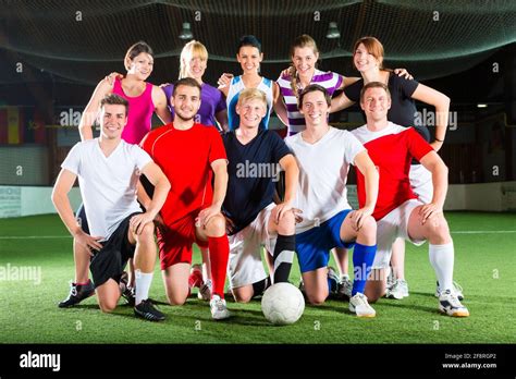 Men and women in mixed sport team playing football or soccer indoor Stock Photo - Alamy