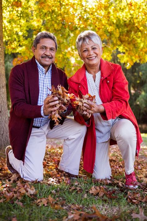 Mature Couple Holding Autumn Leaves At Park Stock Image Image Of Outdoors Front