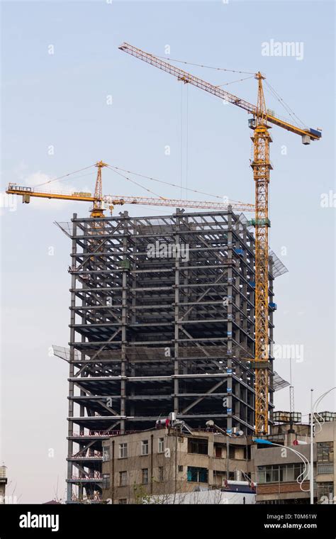 Tall Building Under Construction With Scaffolding And Tower Crane Stock