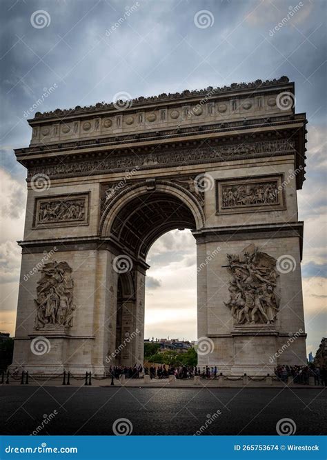 Exterior Of Arc De Triomphe Under Dramatic Cloudy Sky In Paris France