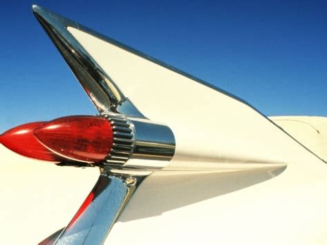 The Tail End Of An Old Car With Its Hood Ornament And Chrome Tips