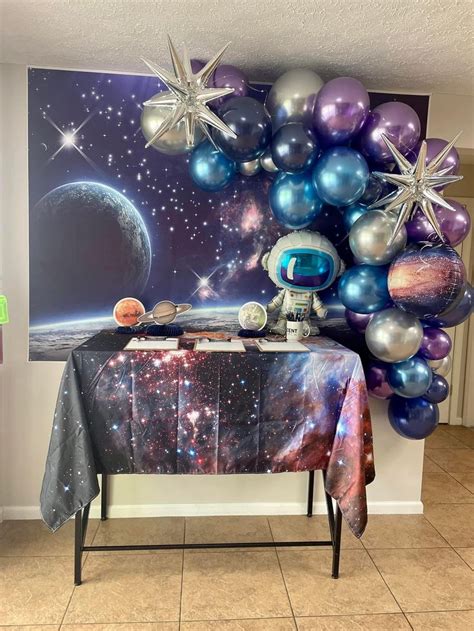 A Space Themed Birthday Party With Balloons And Stars On The Wall