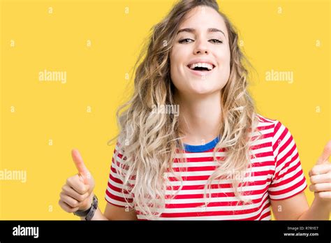 Schöne junge blonde Frau über isolierte Hintergrund erfolg Zeichen tun positive Geste mit der