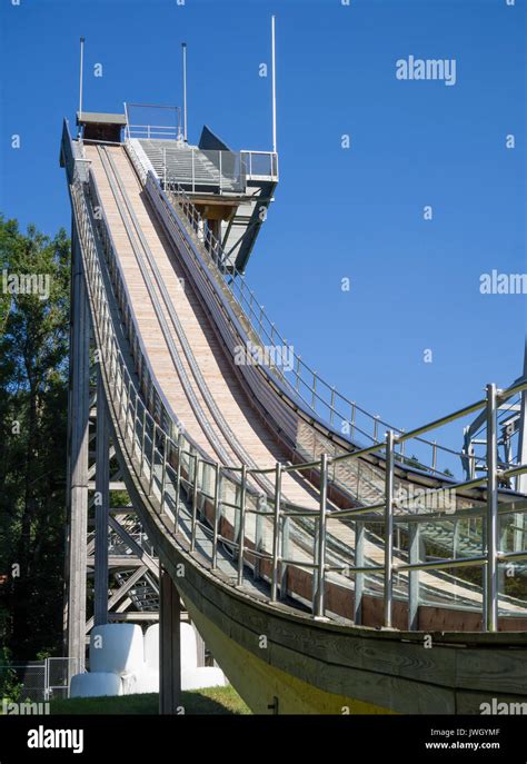 Jump-off platform of a ski jump during summertime. Plastic sliders at the ramp and artificial ...