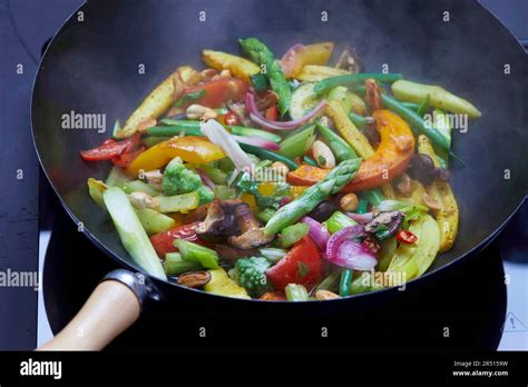 Colorful vegetables cooking in a wok Stock Photo - Alamy