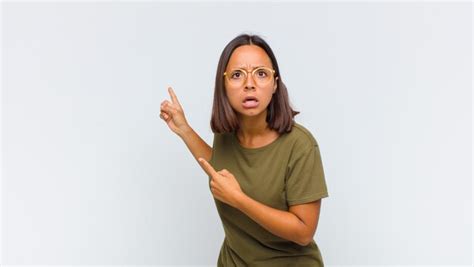 Mujer latina que se siente conmocionada y sorprendida señalando el