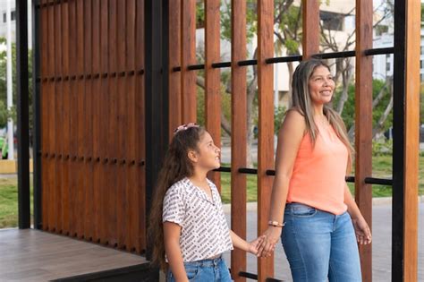 Latina Madre E Hija Tomados De La Mano En Un Parque Foto Premium