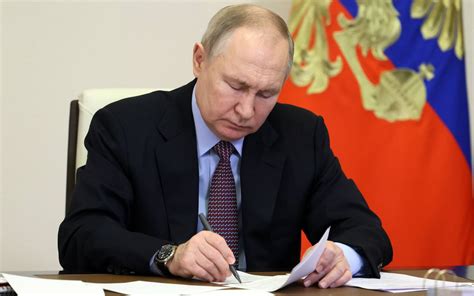 russian president vladimir putin signing official documents