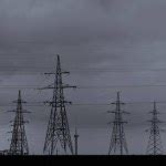 High Voltage Power Lines And Transmission Towers At Sunset Poles And