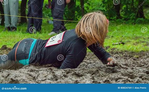 Woman Crawling Through Mud As Part Of Obstacle Course Stock Video