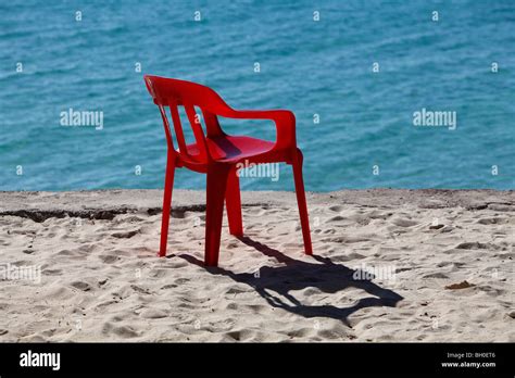 Red plastic chair blue water, Dominican Republic Stock Photo - Alamy