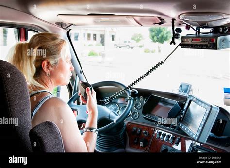 Femme blonde en conversation sur le téléphone cellulaire en conduisant un gros camion Photo