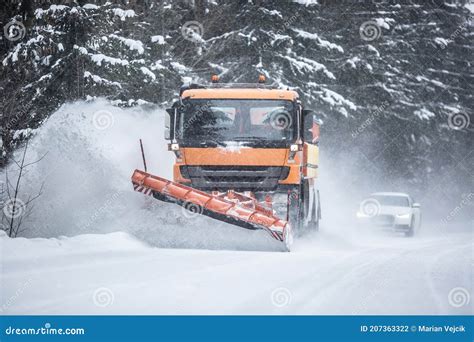 Snowplow Clearing Road From Snow In The Forest With Traffic Lining Up