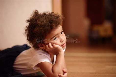 Fille Mignonne De Petit Afro américain S étendant Sur Le Plancher Avec