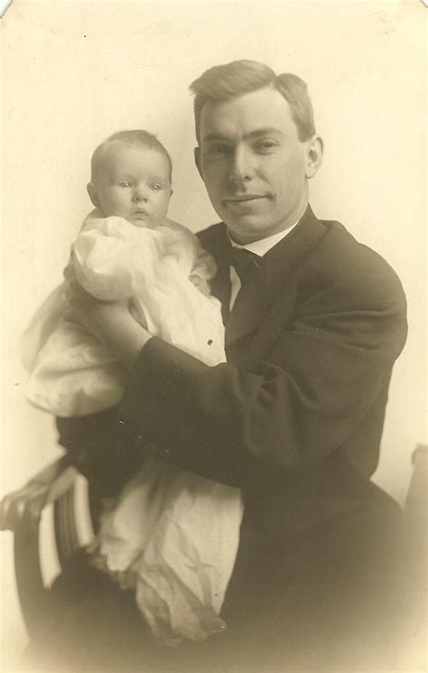 An Old Black And White Photo Of A Man Holding A Baby