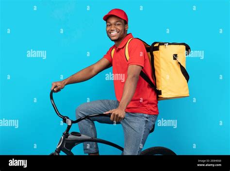 smiling delivery delivery man riding bicycle  studio stock photo alamy