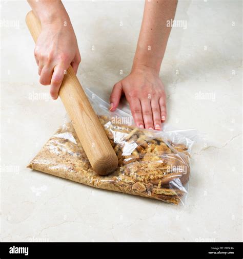 Crushing Biscuits In Plastic Bag With Rolling Pin To Make Biscuit