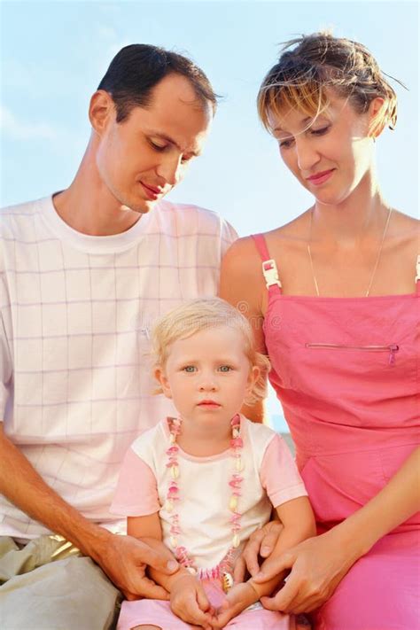 Família Feliz Na Praia Pais Que Olham a Menina Imagem de Stock