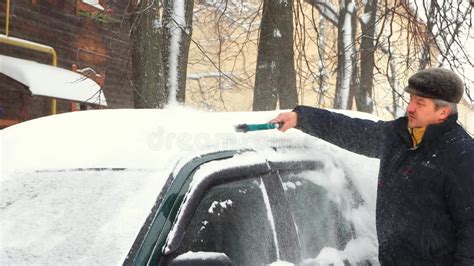 A Man Cleans His Car Of Snow With A Brush It Is Snowing Stock Video