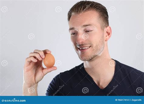 Handsome Blond Man On Smiling Face Looking Egg In Studio Stock Photo