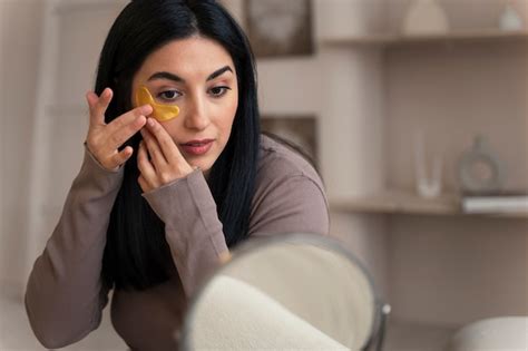 Mujer Disfrutando De Su Rutina De Belleza Con Parches Dorados En Los