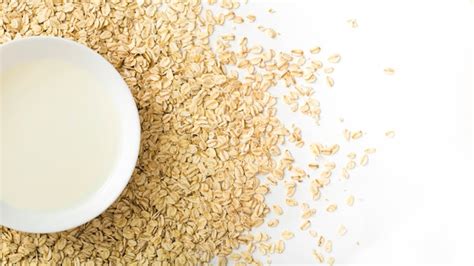 Premium Photo | Healthy milk bowl over the dry oats flakes on the white background