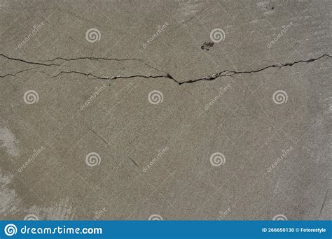 A Cracked Concrete Wall Covered With A Gray Cement Texture As A