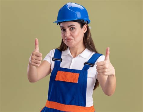 Mulher Jovem Construtora Satisfeita De Uniforme Mostrando Os Polegares