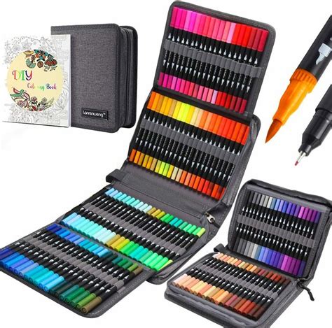 an assortment of colored pencils in a case with a pen and drawing book ...