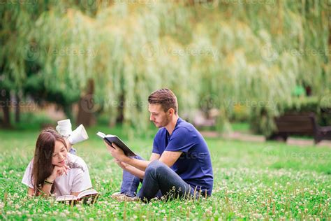 Relaxed Young Couple Reading Books While Lying On Grass 18106572 Stock