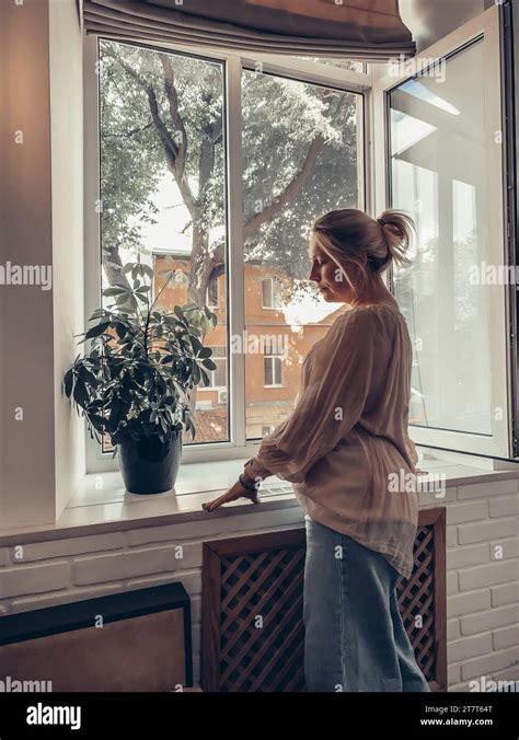 A Woman Looks Out The Window Stock Photo Alamy