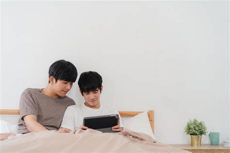 Jeune Couple Gay Asiatique Utilisant Une Tablette La Maison Photo De Stock Chez Vecteezy