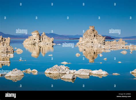 Classic View Of Fascinating Tufa Rock Formations Mirrored On Calm Water