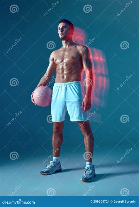 Muscular Male Athlete Posing With Pink Ball In White Shorts On Blue Background With Naked Torso
