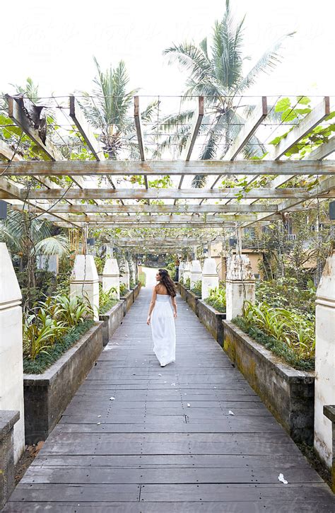 Woman Walking Over Pergola Covered Bridge By Stocksy Contributor