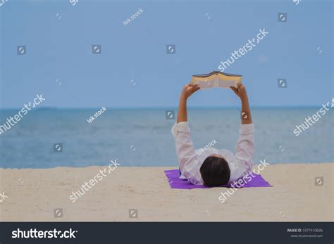 Woman Lying On Beach Reading Book Stock Photo 1977410696 | Shutterstock