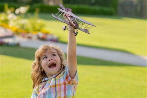 Infancia feliz niño piloto aviador con alas de papel o avión de juguete