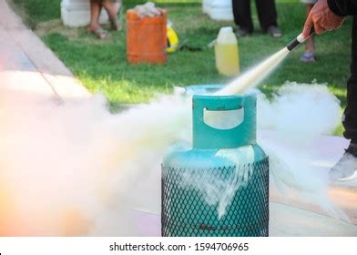 Man Using Fire Extinguisher Fighting Fire Stock Photo