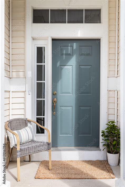 A cozy front door and small front porch with a blue door, tan siding ...