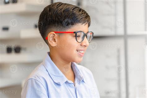 Smiling Indian boy choosing glasses in optics store, Portrait of Mixed ...