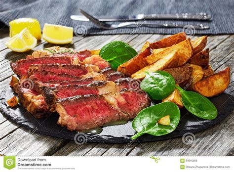 O Bife Marmoreado Meio Raro Grelhado Do Ribeye Cortou Nas Fatias Foto