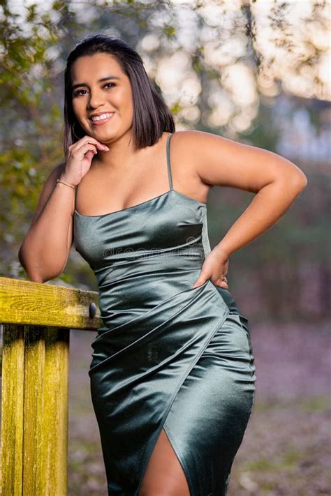 Photo Verticale D Une Jeune Femme Latina Attrayante En Robe De Soie Verte Posant Dans Un Parc