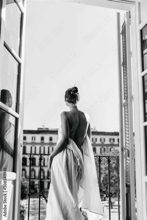 A Girl Resting At The Hotel Stands In The Opening Of An Open Balcony